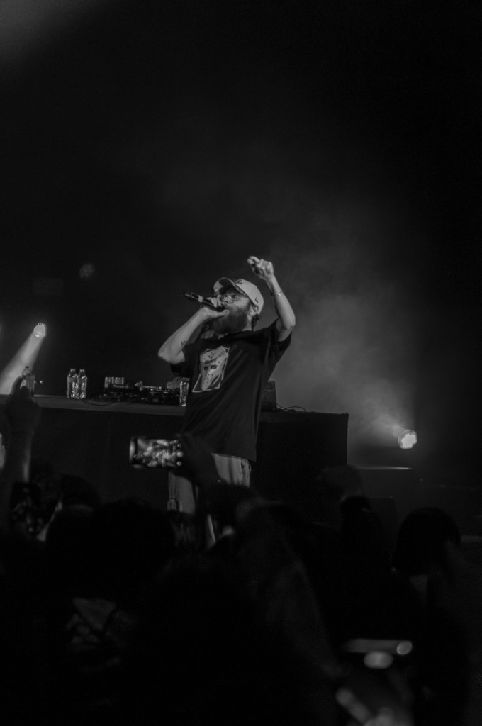 Germ raises the mic mid-song under the Aztec Theatre's stage lights